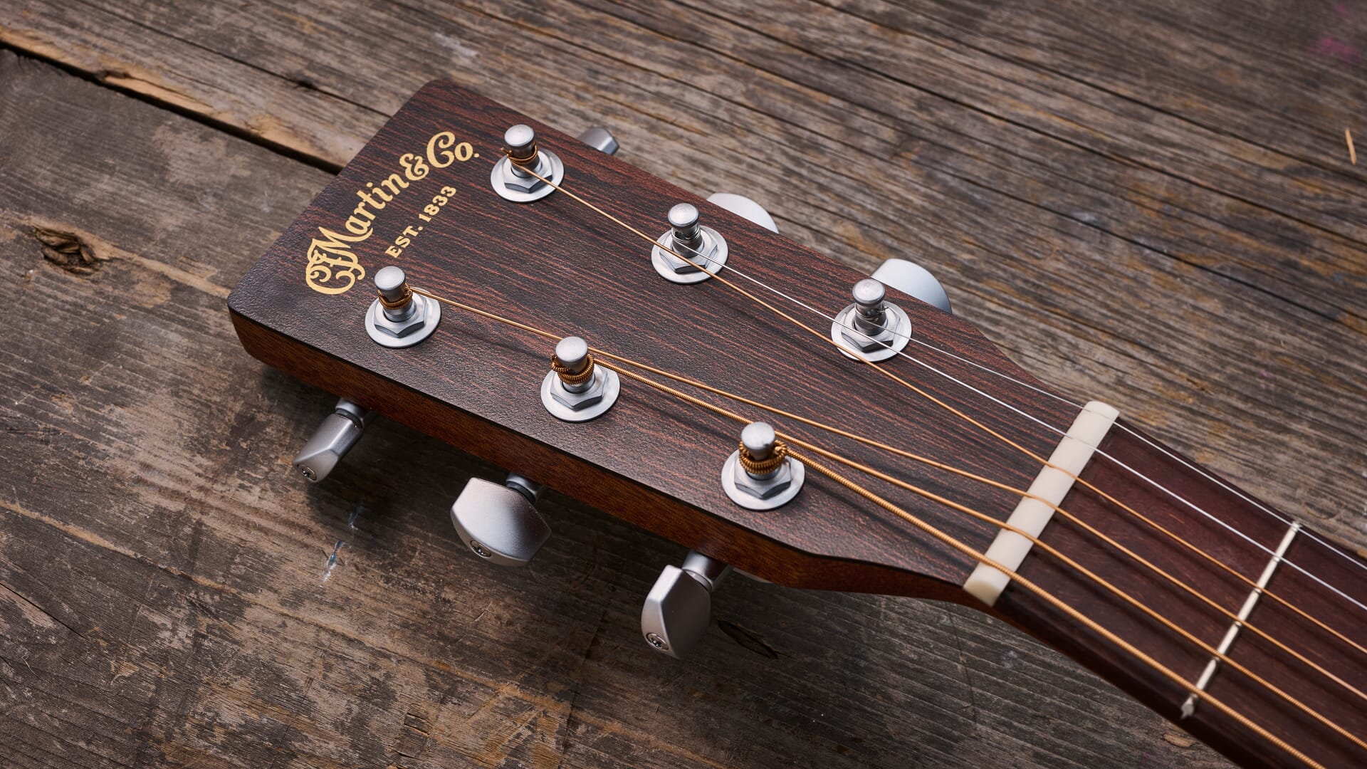 Martin guitar headstock showing gold C.F. Martin and Co. Est. 1833 logo with open-gear tuners